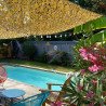 Voile d'ombrage en filet de camouflage beige au-dessus d'une piscine