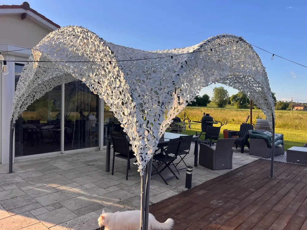 Filet de camouflage blanc tendu en voûtes au-dessus d'une terrasse