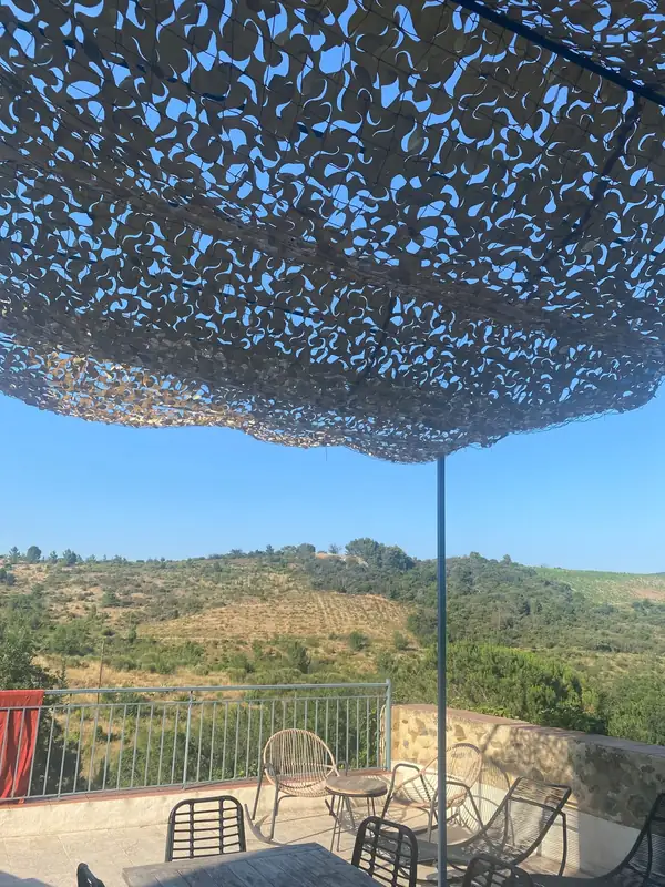 Filet beige au-dessus d'une terrasse avec vue sur les collines
