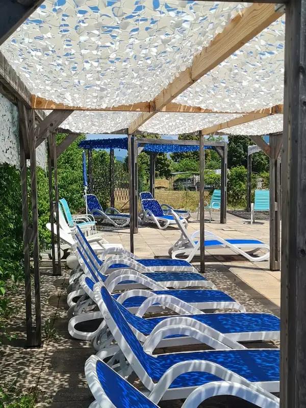 Filets blancs ombrageant une rangée de bains de soleil