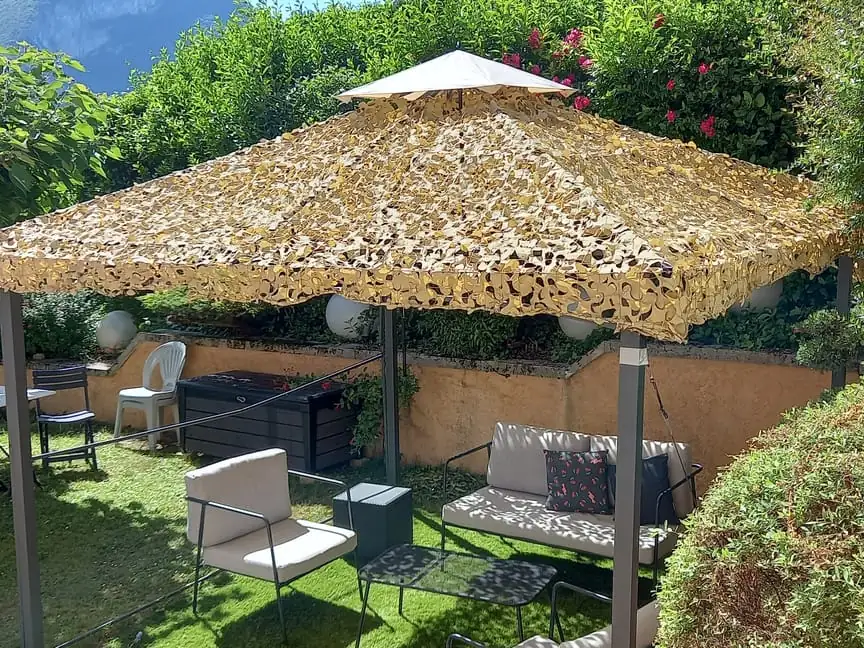 Kiosque de jardin couvert d'un filet beige