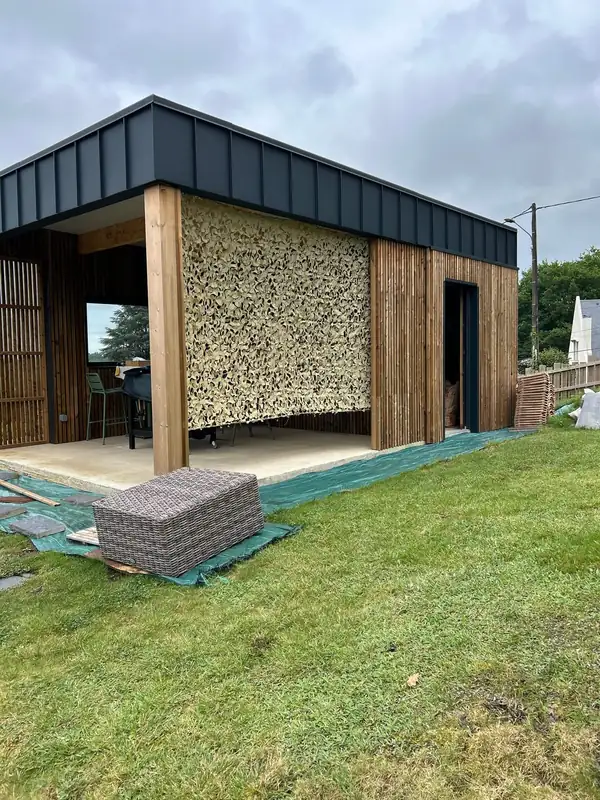 Filet beige en brise-vue sur un pool house en bois