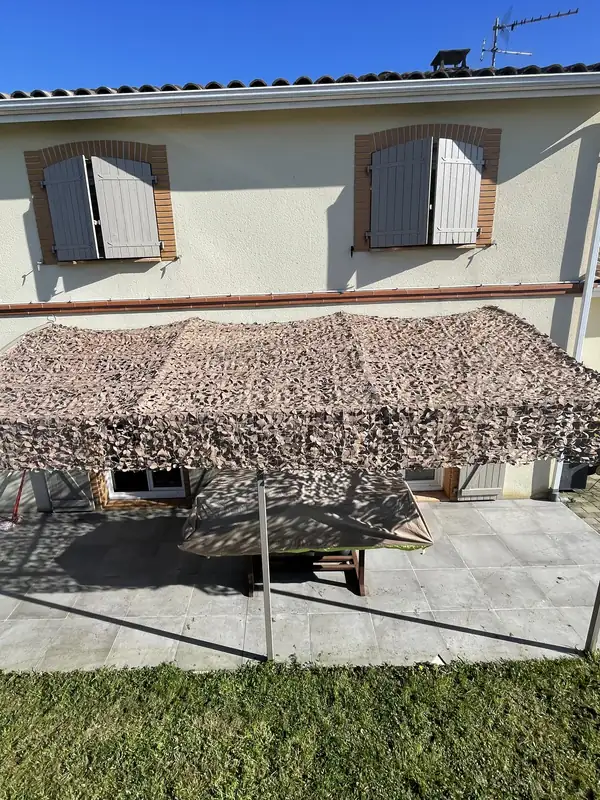 Filet de camouflage sur une structure métallique en ombrière